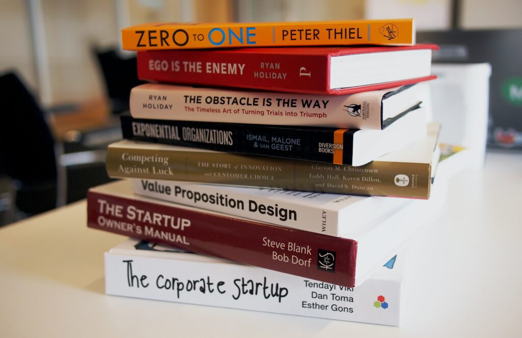 Image featuring a stack of research books on acquisition, symbolizing the importance of thorough analysis and knowledge gathering before initiating a business acquisition.